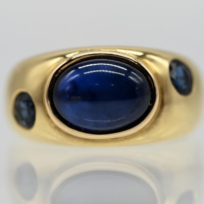 Los Nr. 025 Massiver Bandring mit Saphir-Cabochon und 2 Saphiren, Goldschmiedearbeit NM, 21. Jh.