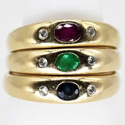 Los Nr. 010 3 verschiedene Bandringe, jeweils mit Saphir, Rubin und Smaragd und seitlich je 1 Brillant, 80er Jahre